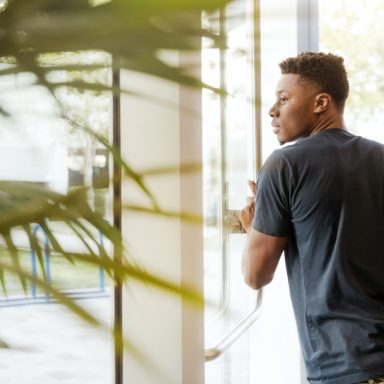 man looking outside window carrying black and brown backpack 1251861