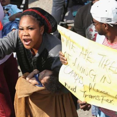 asylum seekers in camps w sign