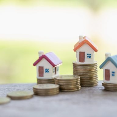 Houses on a stack on money.